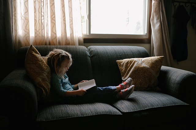 malé dítě si čte u okna